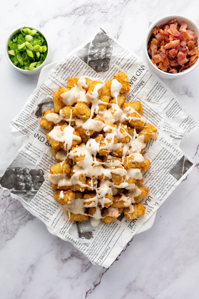 tater tots with sour cream drizzled on top