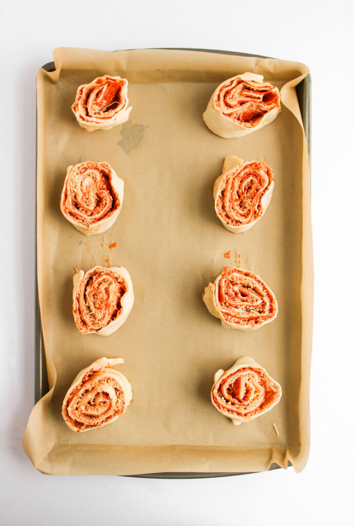 pizza pinwheels on parchment paper before baking