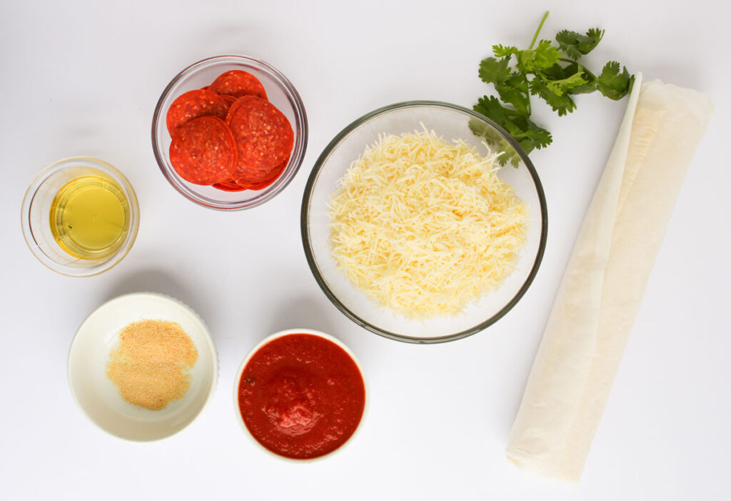 pizza pinwheels ingredients in bowls on countertop