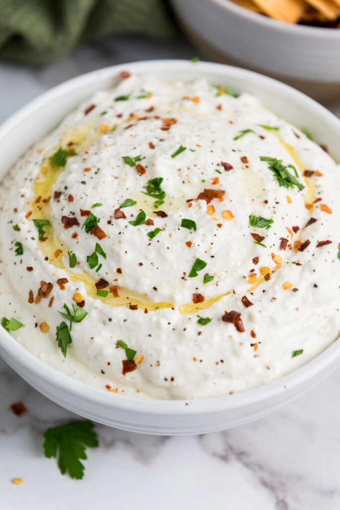close up of whipped feta dip in white bowl