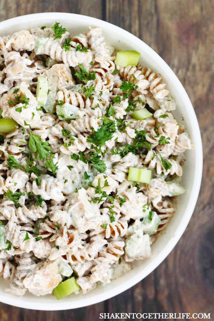 white bowl with creamy chicken pasta salad with chopped celery