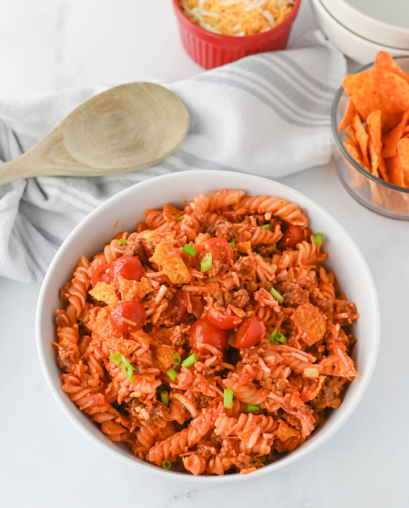 taco pasta salad in a white bowl with wooden sppon
