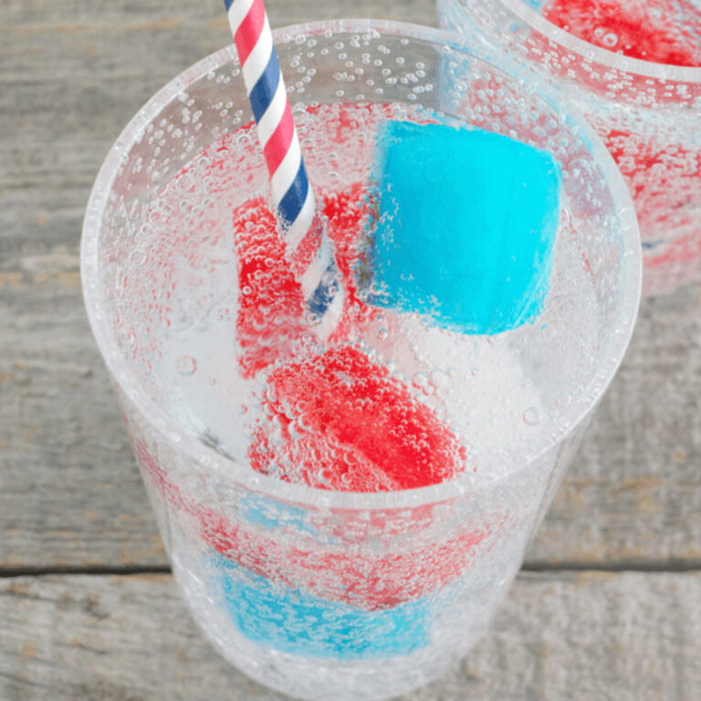 red, white, and blue ice cubes in a clear glass of soda