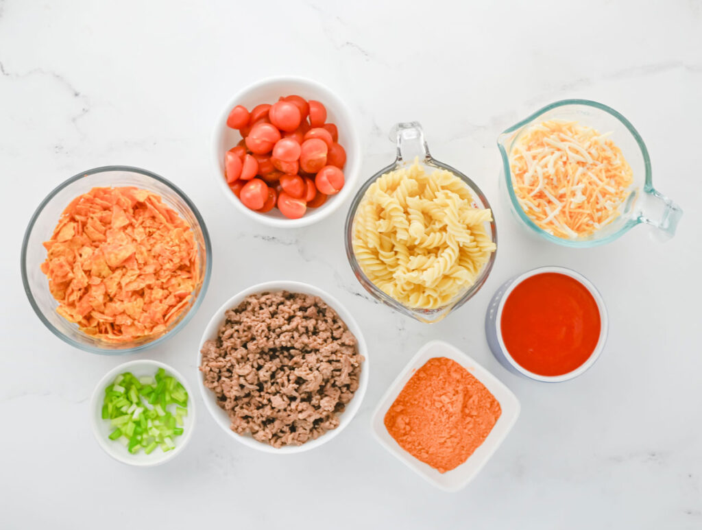 taco pasta salad ingredients in bowls on counter