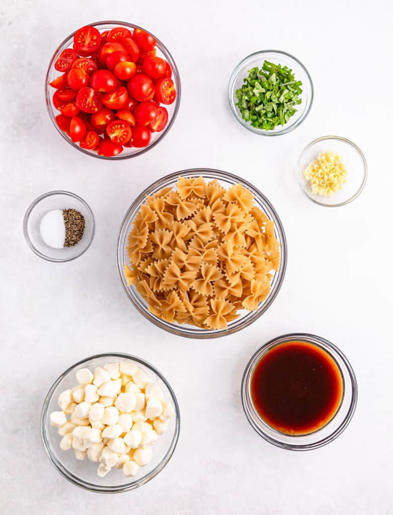 caprese pasta salad ingredients in bowls on countertop