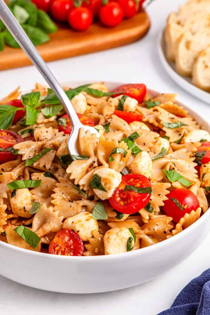 spoon in bowl of caprese pasta salad