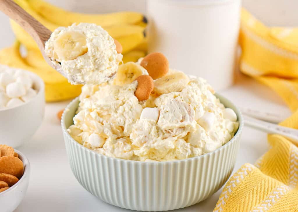 spoon scooping banana pudding fluff salad from bowl