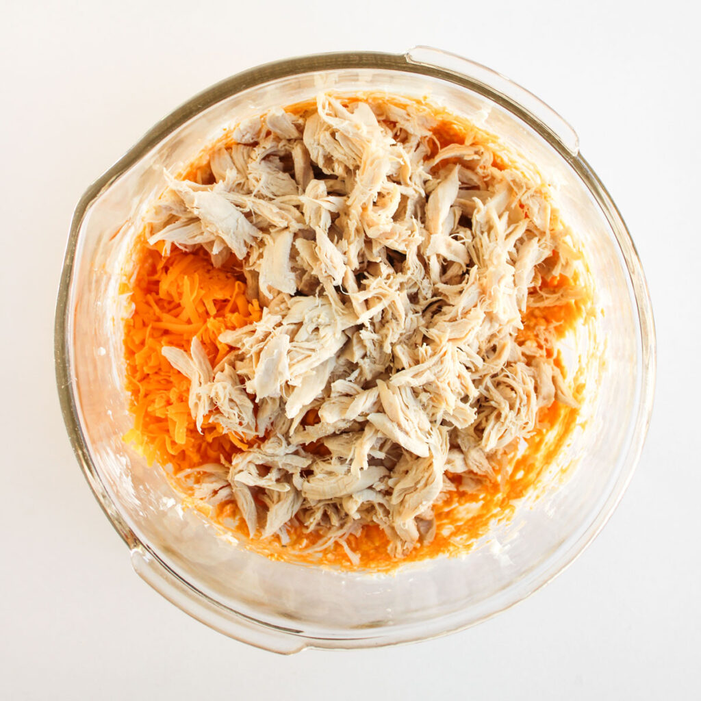 mixing buffalo chicken filling in glass bowl