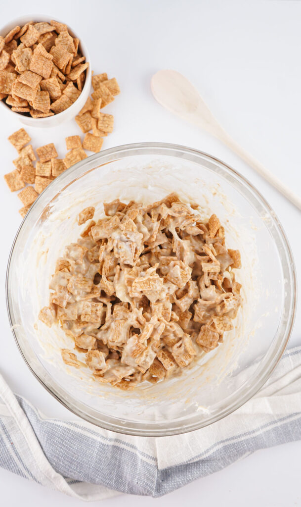 mixing cinnamon toast crunch treats in glass bowl