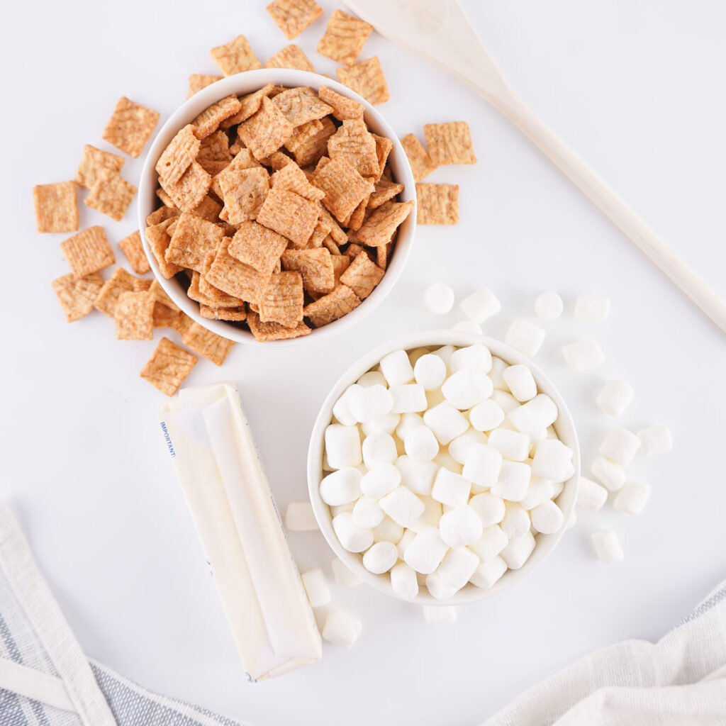 cinnamon toast crunch, butter, and marshmallows in bowls on counter for cinnamon toast crunch treats