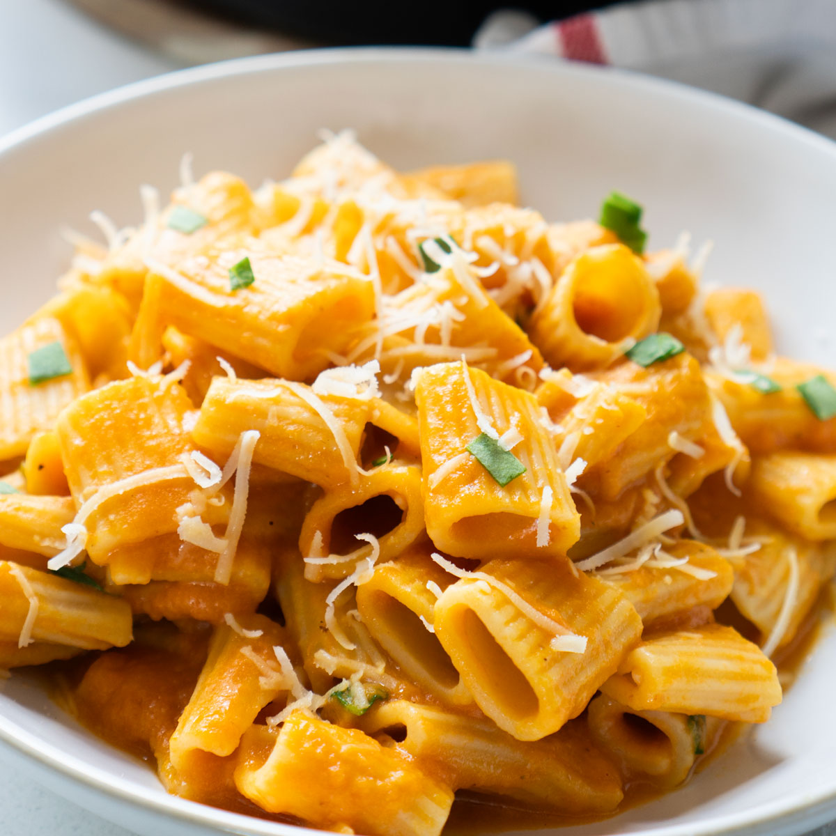creamy pumpkin pasta in white bowl