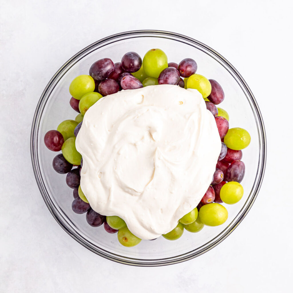 bowl of grapes with cream cheese dressing on top