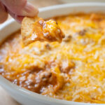 chip dipping into enchilada dip