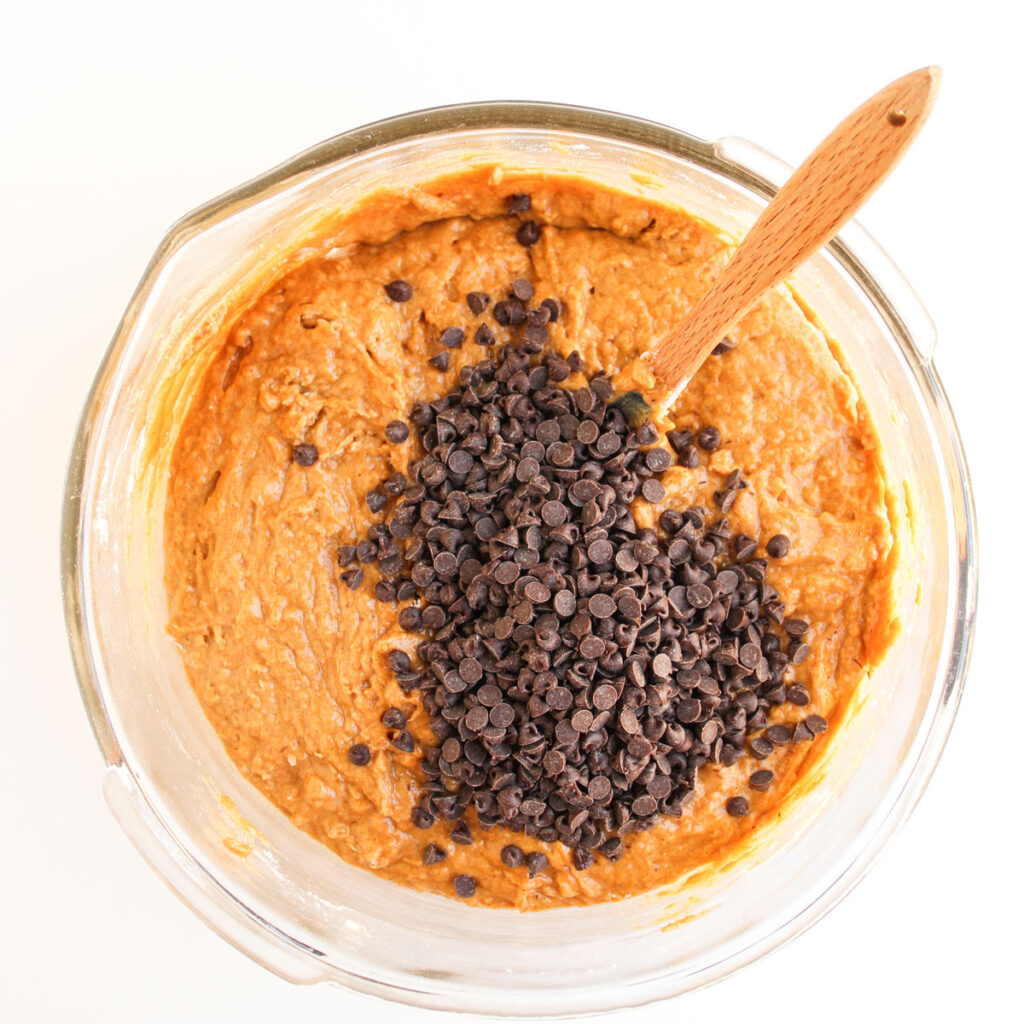chocolate chips on top of pumpkin chocolate chip muffins batter