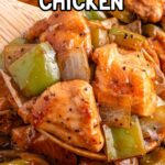 close up of wooden spoon with black pepper chicken and recipe name overlay