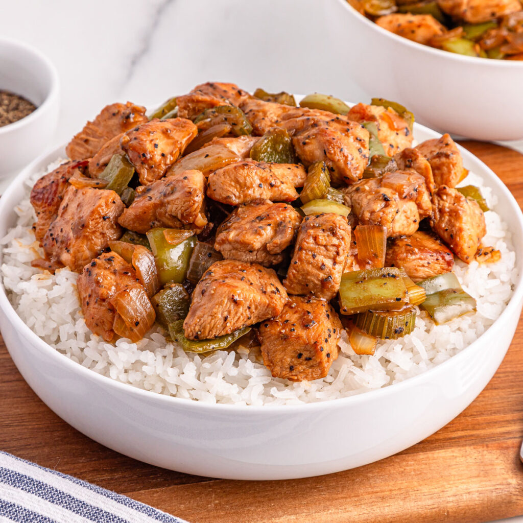 bowl of black pepper chicken over rice