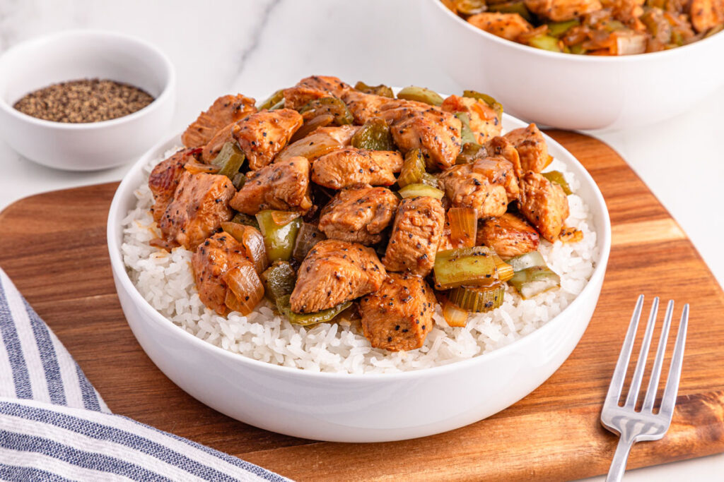 white bowl with black pepper chicken over rice