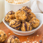 white bowl with peanut butter oatmeal balls and one bitten into