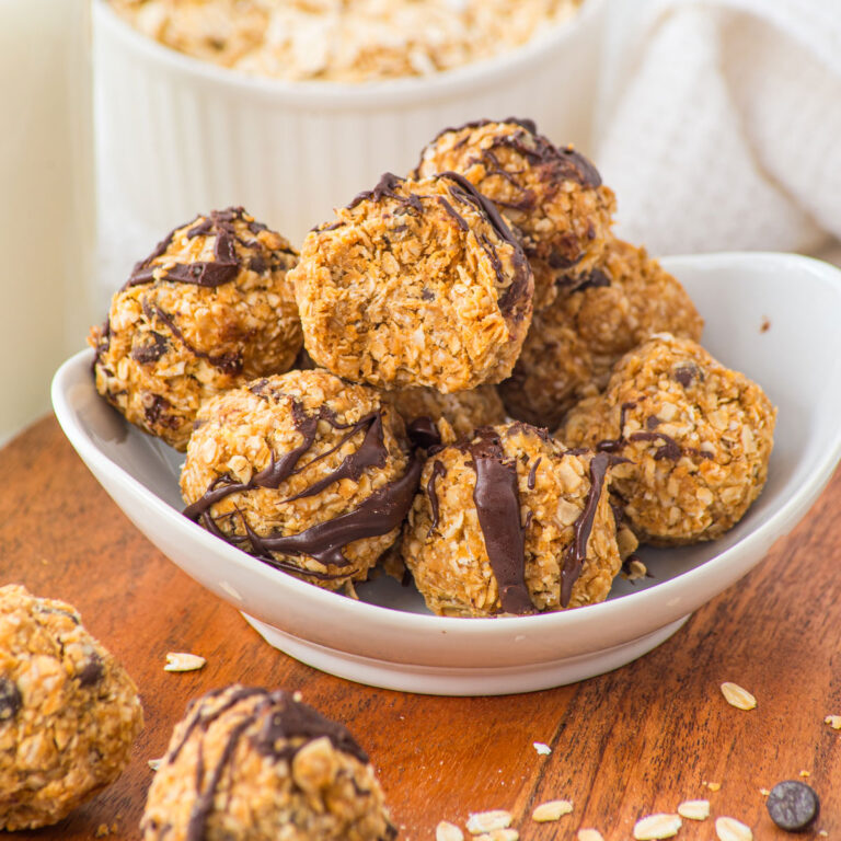 white bowl with peanut butter oatmeal balls and one bitten into