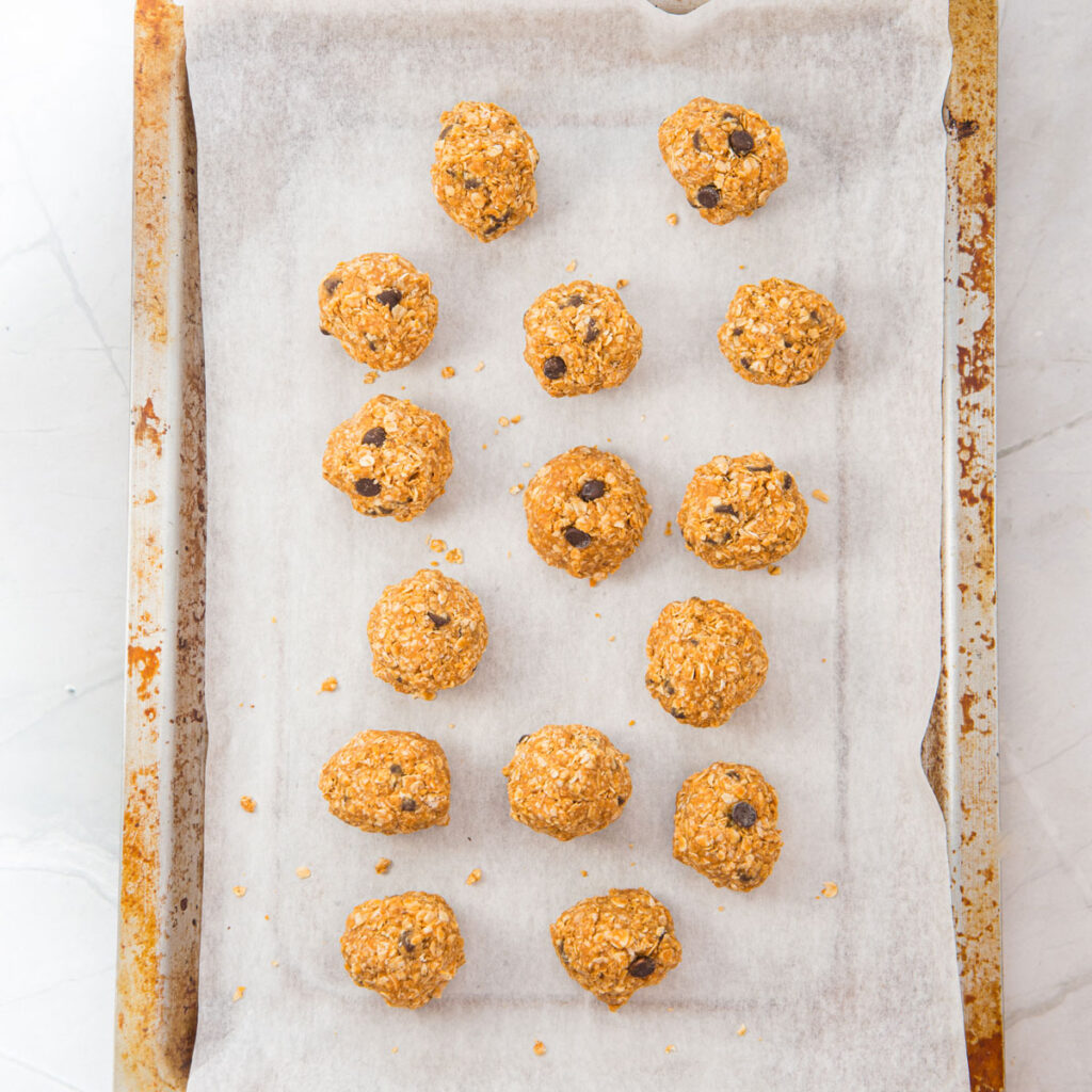 peanut butter oatmeal balls on baking sheet lined with parchment paper