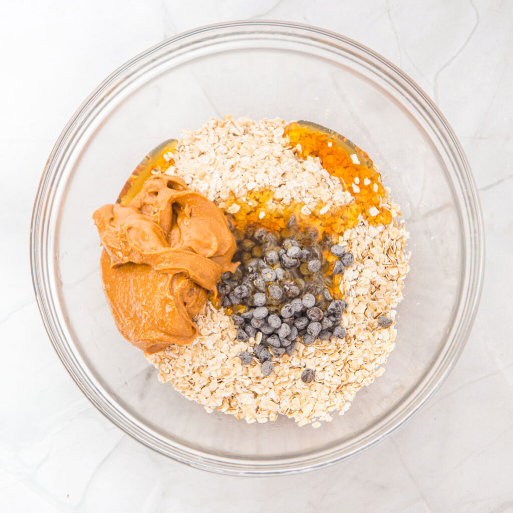 peanut butter oatmeal balls ingredients in glass bowl before mixing