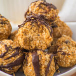 peanut butter oatmeal balls in bowl with top one bitten into