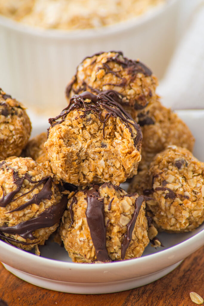 peanut butter oatmeal balls in bowl with top one bitten into