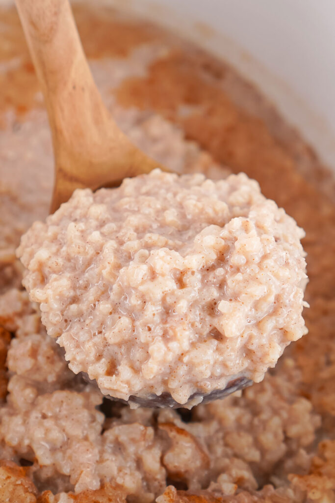 close up of scoop of slow cooker rice pudding