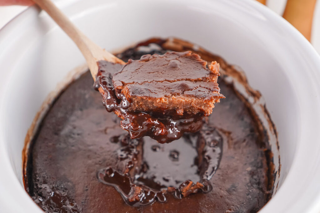 spoon scooping slow cooker chocolate cobbler