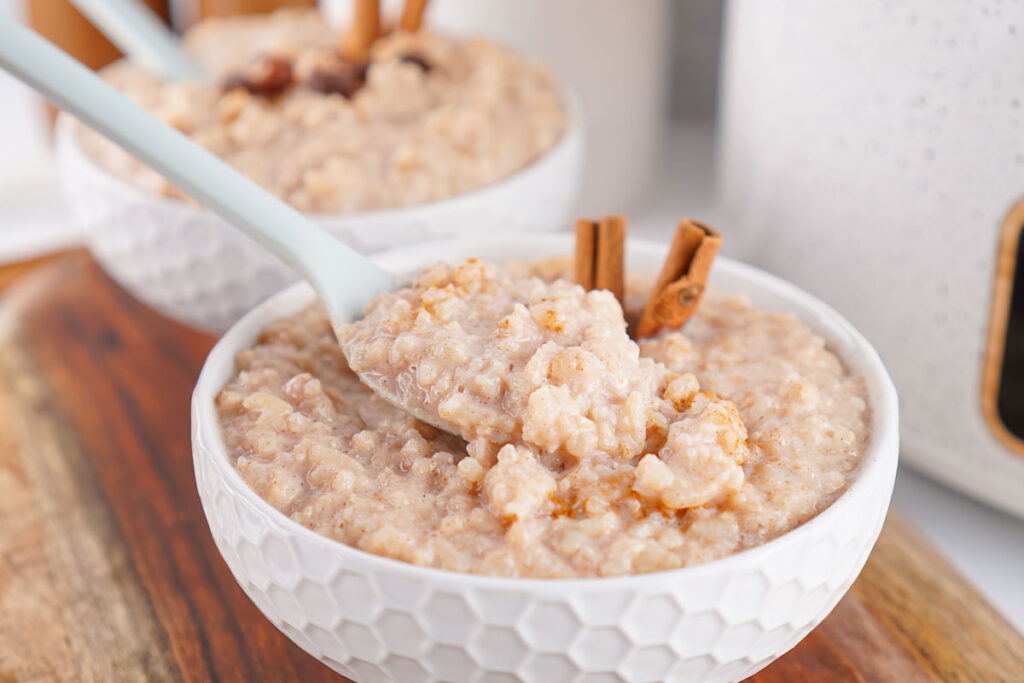 spoon scooping slow cooker rice pudding from bowl