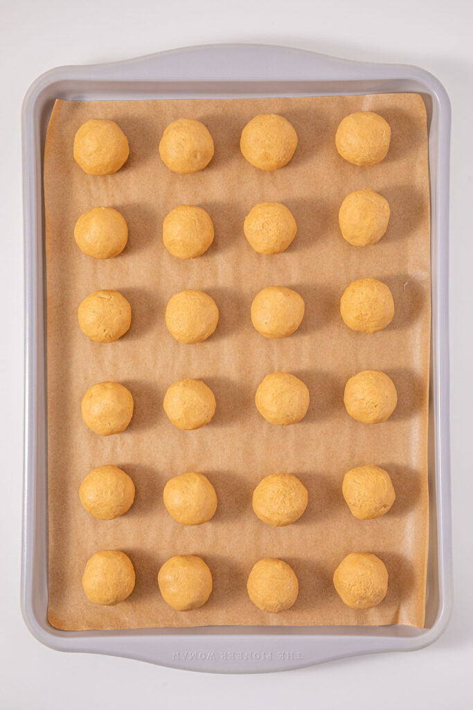 peanut butter balls on baking sheet for making buckeye candies