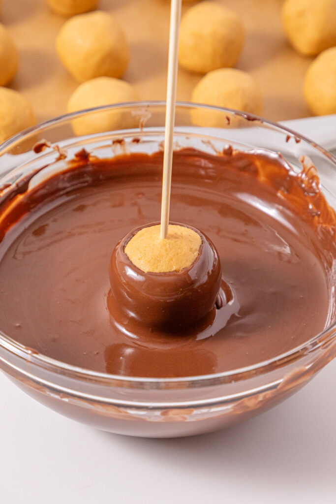 making buckeye candies dipping in chocolate