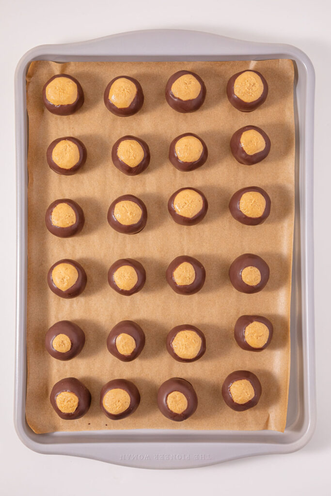 buckeye candies on parchment paper lined baking sheet