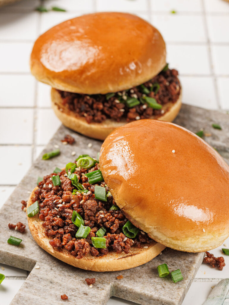 two korean sloppy joes on cutting board