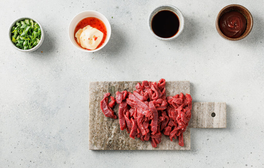 korean sliced beef with korean loaded fries ingredients in bowls