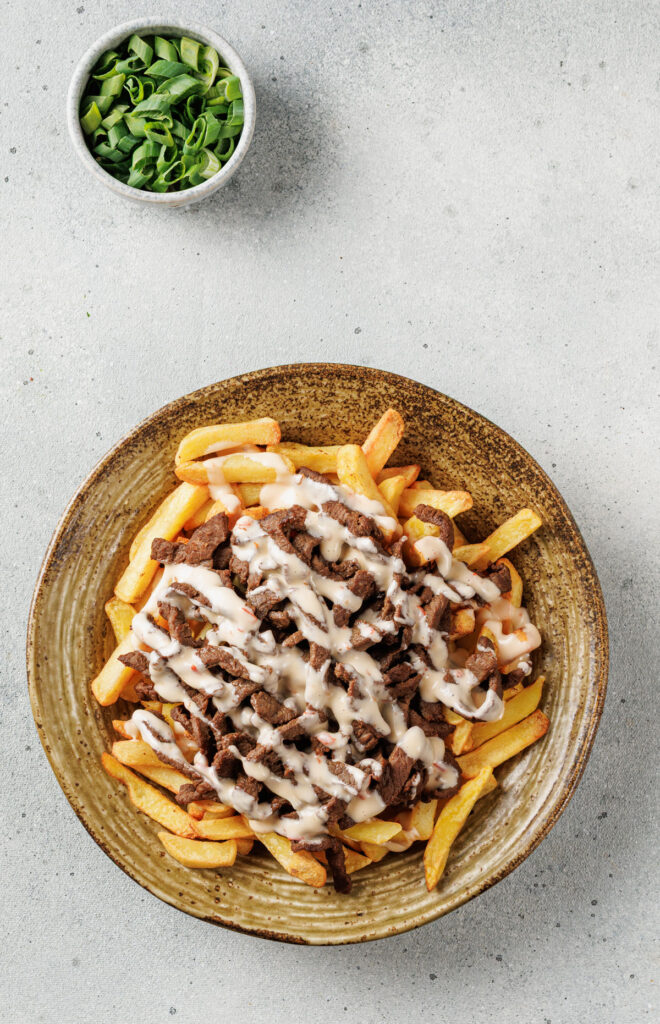 korean loaded fries and chopped green onion in bowl