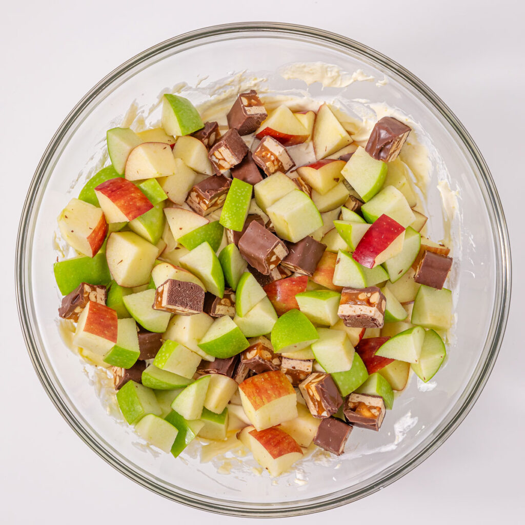snickers apple salad ingredients in bowl before mixing together