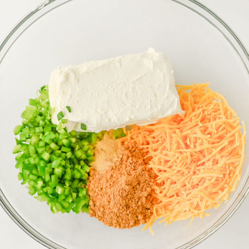 taco cheeseball ingredients in glass bowl before mixing
