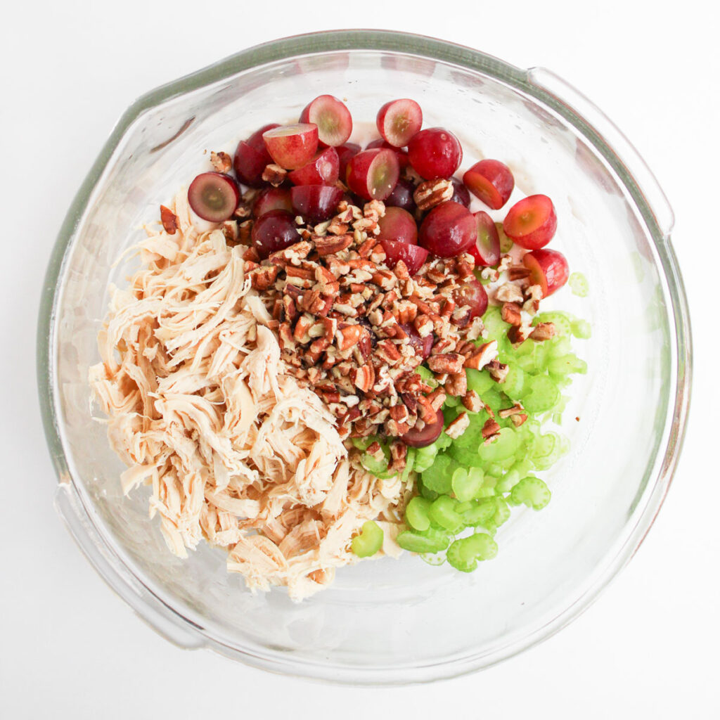 chicken salad ingredients in glass bowl before mixing