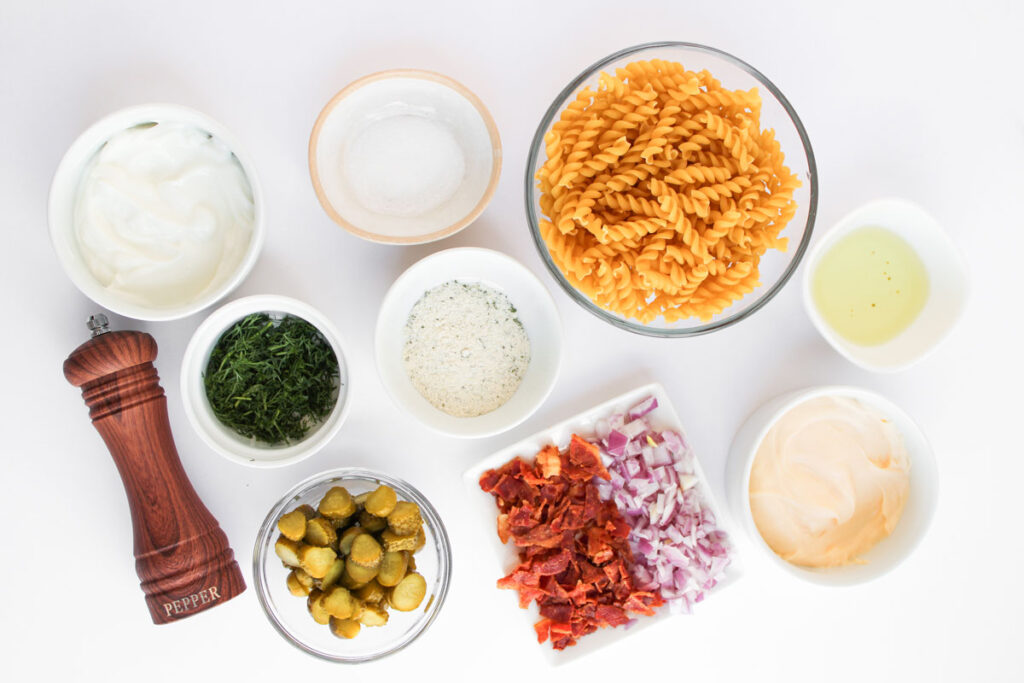pickle pasta salad ingredients in bowls on countertop