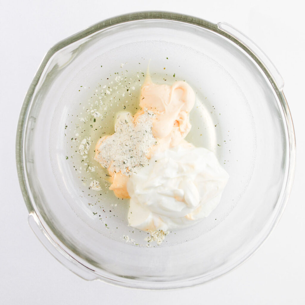 pasta salad dressing ingredients in glass bowl before mixing