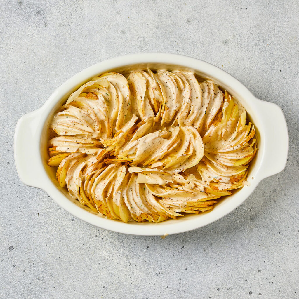 scallop potatoes in white baking dish before baking